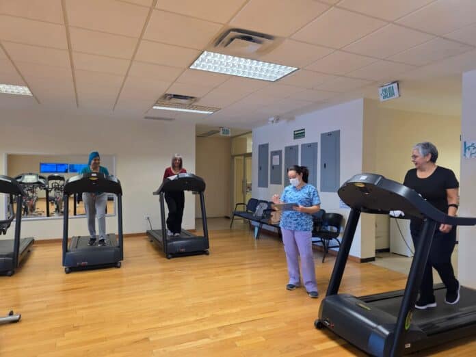 Personas ejercitándose en una clínica de rehabilitación en una caminadora, con un ambiente de sala de terapia, importancia de la salud y el bienestar en Chihuahua, México.