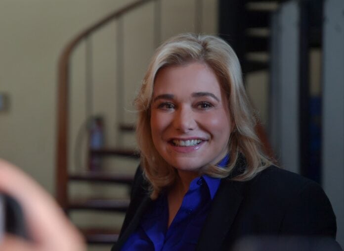 Chica sonriendo con expresión profesional, en un ambiente interior, representando confianza y éxito, ideal para contenido enfocado en negocios, liderazgo y desarrollo personal.
