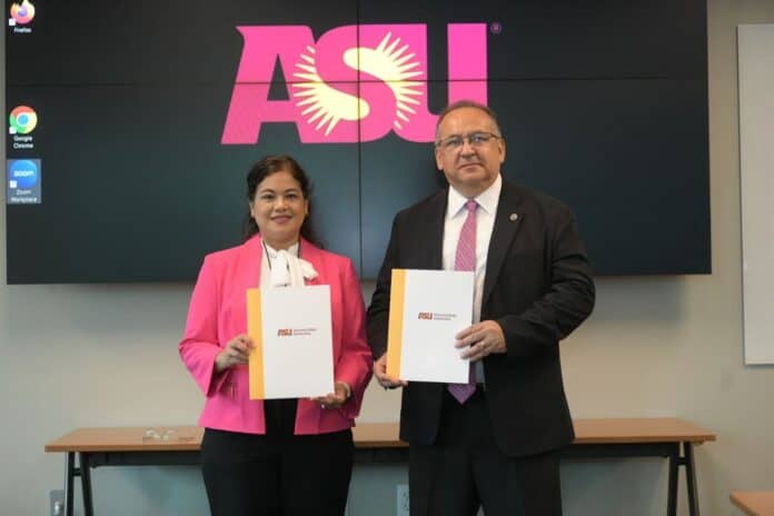 IMG-20250929-WA0037 Soy mujeres en una ceremonia universitaria, sosteniendo documentos oficiales, en un entorno profesional con logotipo de ASU (Arizona State University) en el fondo.