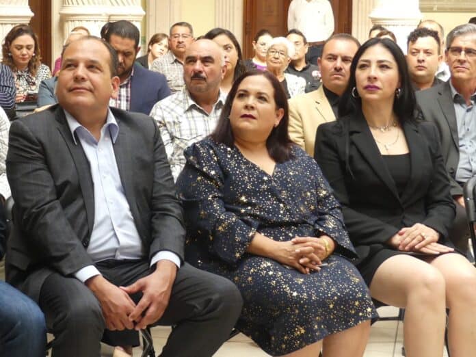 IMG-20250930-WA0006 Adultos en audiencia en evento oficial en Chihuahua, México,con un ambiente formal, resaltando la importancia de eventos políticos y sociales en la región.
