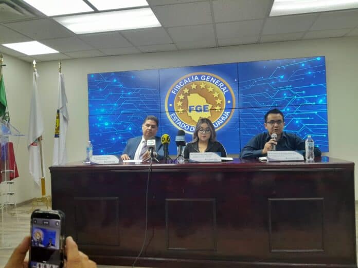 Fiscales en conferencia con fondo digital que muestra "FISCALÍA GENERAL ESTADO CHIHUAHUA" y logotipo de la fiscalía del estado.