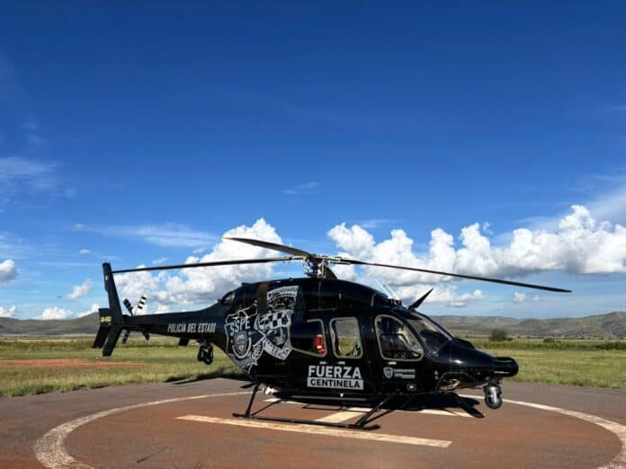 b88379ab-c5fd-4b05-aa49-fa54f2833197 Helicóptero de la policía estatal de Chihuahua en un helipuerto al aire libre bajo cielo azul despejado, utilizado en operaciones de seguridad y vigilancia en el estado de Chihuahua.