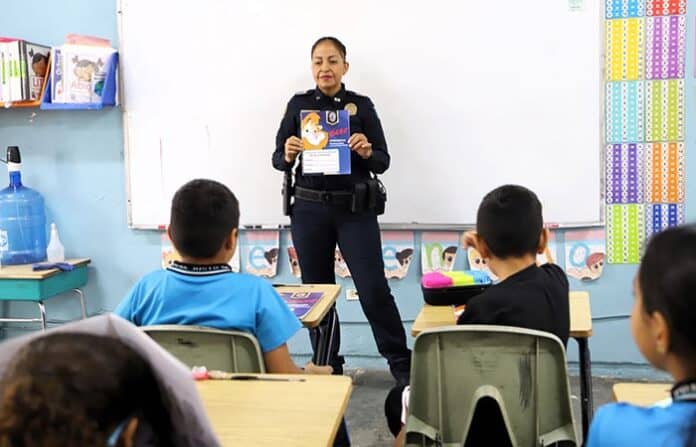 Resultado de la búsqueda de la policía en el aula en Chihuahua, México, para promover la seguridad y la educación comunitaria. La policía interactúa con niños en un entorno escolar, fomentando la confianza y la prevención del delito.