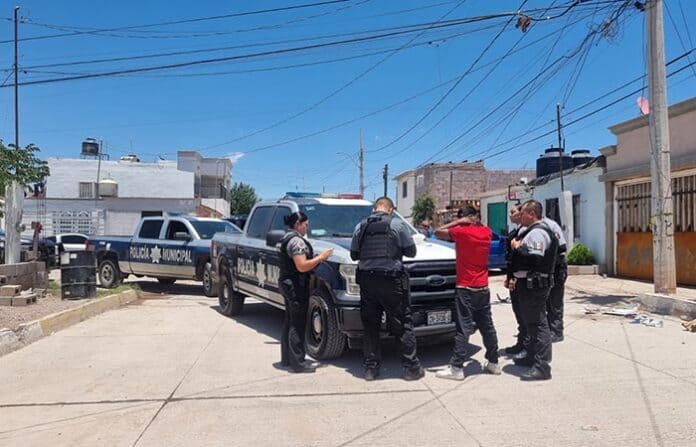 denundrogas Camioneta de la policía municipal interactuando con personas en una calle de Chihuahua, atendiendo una situación de seguridad pública en la ciudad.