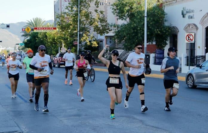 Corredores participando en una carrera en las calles de Chihuahua, disfrutando de una actividad deportiva al aire libre para promover salud y bienestar en la comunidad.