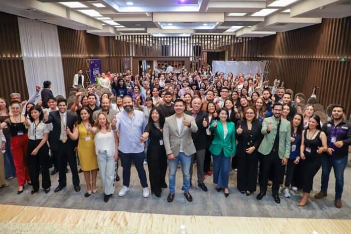 5f86ebbc-853f-46ac-960e-ffc9ab3ec1be Personas participando en un evento empresarial en un salón moderno, promoviendo networking y desarrollo profesional en Chihuahua.