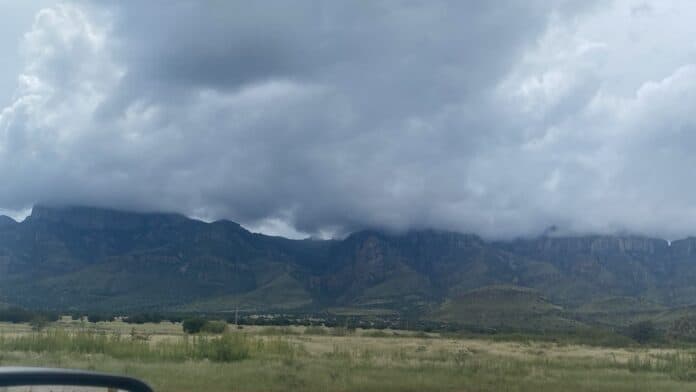 Nube oscura cubriendo las montañas en un paisaje natural de Chihuahua, México, bajo un cielo nublado y lluvioso, ideal para contenido sobre clima y naturaleza en la región.