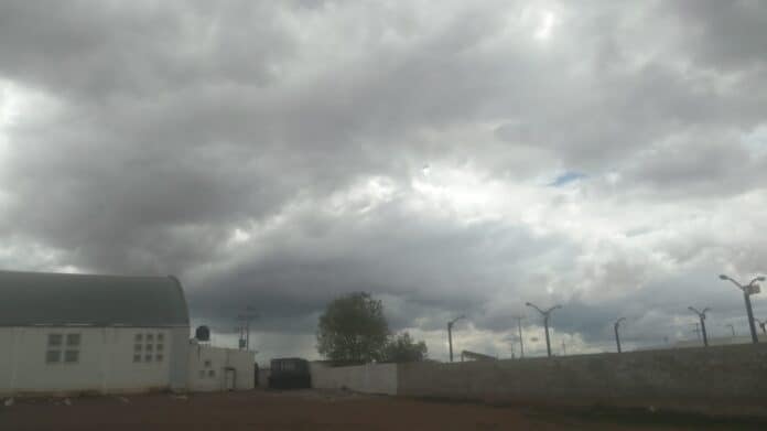 IMG-20250915-WA0066 Nube grisácea y cielo tormentoso sobre el paisaje urbano de Chihuahua, México, con alumbrado público y edificaciones, reflejando el clima lluvioso y nublado en la región.