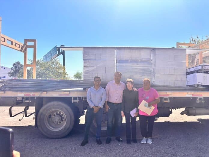 IMG-20251002-WA0019 Camion de mudanzas con cuatro personas posando frente a un edificio en construcción, mostrando logros en proyectos de infraestructura y desarrollo en Chihuahua, México.