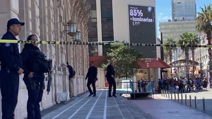 Policías en la calle en un operativo de seguridad en una zona urbana de Chihuahua, con edificios modernos, una pantalla digital y un ambiente concurrido, resaltando la seguridad en la ciudad.