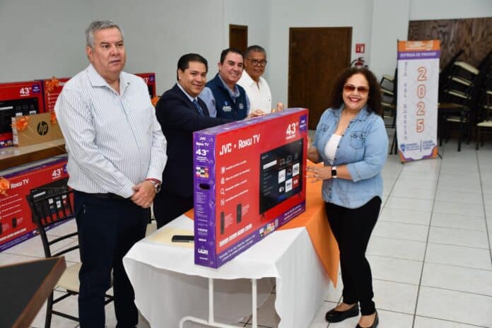 Electores entregando premio de un televisor 43 pulgadas en un evento oficial en Chihuahua, con autoridades y representante del premiado.