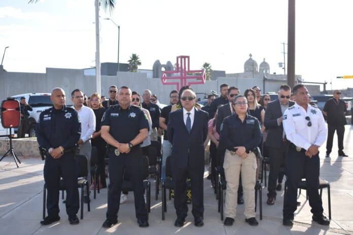 Policías y autoridades en evento oficial en Chihuahua, participando en ceremonia cívica, con presencia de oficiales uniformados, en un acto de respeto y seguridad pública.