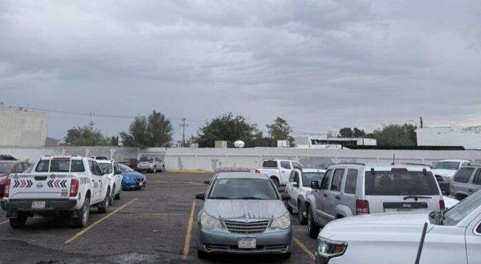 Autos estacionados en un estacionamiento en Chihuahua, México, con cielo nublado, ideal para contenido sobre servicios de estacionamiento en Chihuahua y noticias locales.