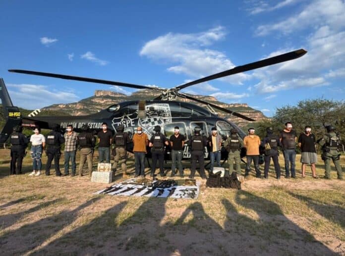 IMG-20251009-WA0033 Policía Estatal de Chihuahua con helicóptero y personas aseguradas en operativo en el área rural de Chihuahua.