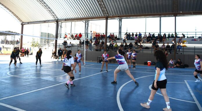 Jugadoras de voleibol en cancha techada, competencia deportiva en Chihuahua, eventos deportivos en el estado, instalaciones deportivas de calidad, deporte femenino en Chihuahua, gimnasio cubierto para voleibol.