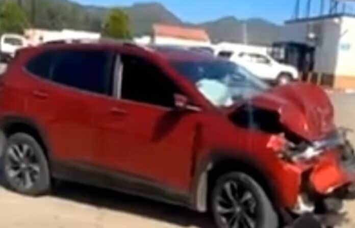 Accidente automovilístico con vehículo rojo con daños en la parte frontal en un lote de autos, en Chihuahua, México, en un día soleado.