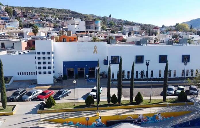 despensasdif Centro comunitario en Chihuahua con áreas verdes y estacionamiento, centrado en actividades sociales y culturales, apoyando a la comunidad local en un entorno moderno y accesible.