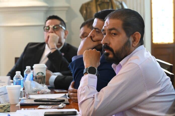 e49df952-6885-4f0c-a8b4-90802d9aa510 Autoridades en una reunión de negocios en Chihuahua, México, discuten temas importantes con atención y concentración, en un entorno formal y profesional, promoviendo decisiones estratégicas.