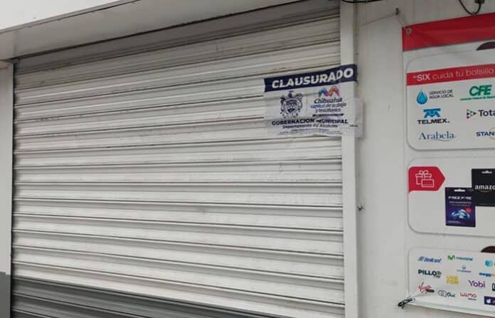 B closed storefront with "Clausurado" sign from Chilihuahua municipal government, indicating business closure.