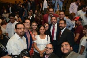 Fotografía de un grupo de personas en evento público en Chihuahua, con líderes y asistentes sonriendo y posando para la cámara. La imagen refleja participación ciudadana y liderazgo en la comunidad.